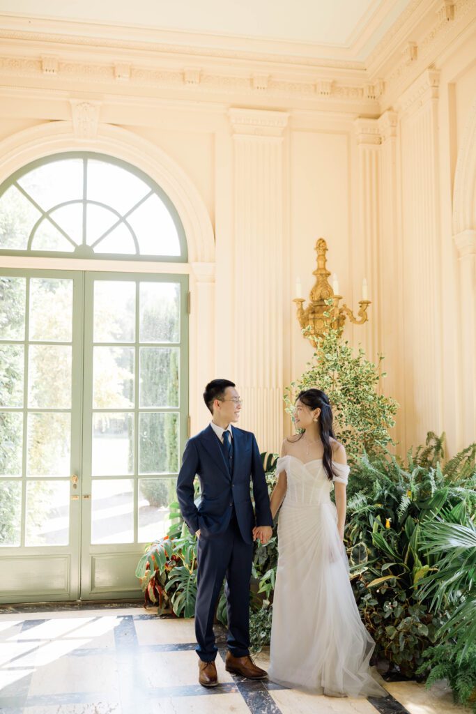 Discover the timeless beauty of a wedding at Filoli Gardens in California, expertly captured by Alyssa Gayle Photography. This enchanting photo showcases a joyful couple against the stunning backdrop of Filoli's historic architecture and lush greenery, embodying elegance and romance. Perfect for those seeking inspiration for a garden wedding venue.