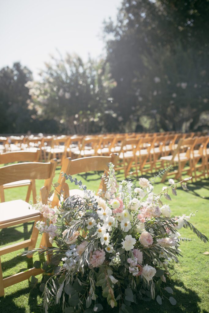 Ceremony seating at Holman Ranch with rows of wooden chairs facing the altar, overlooking vineyard and mountain views.