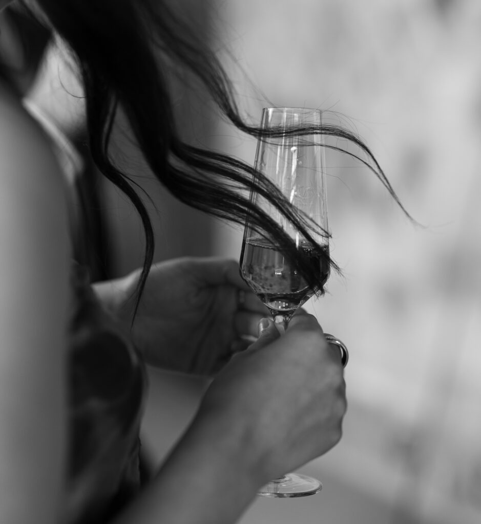 Black and white photo of champagne being poured during wedding celebration
