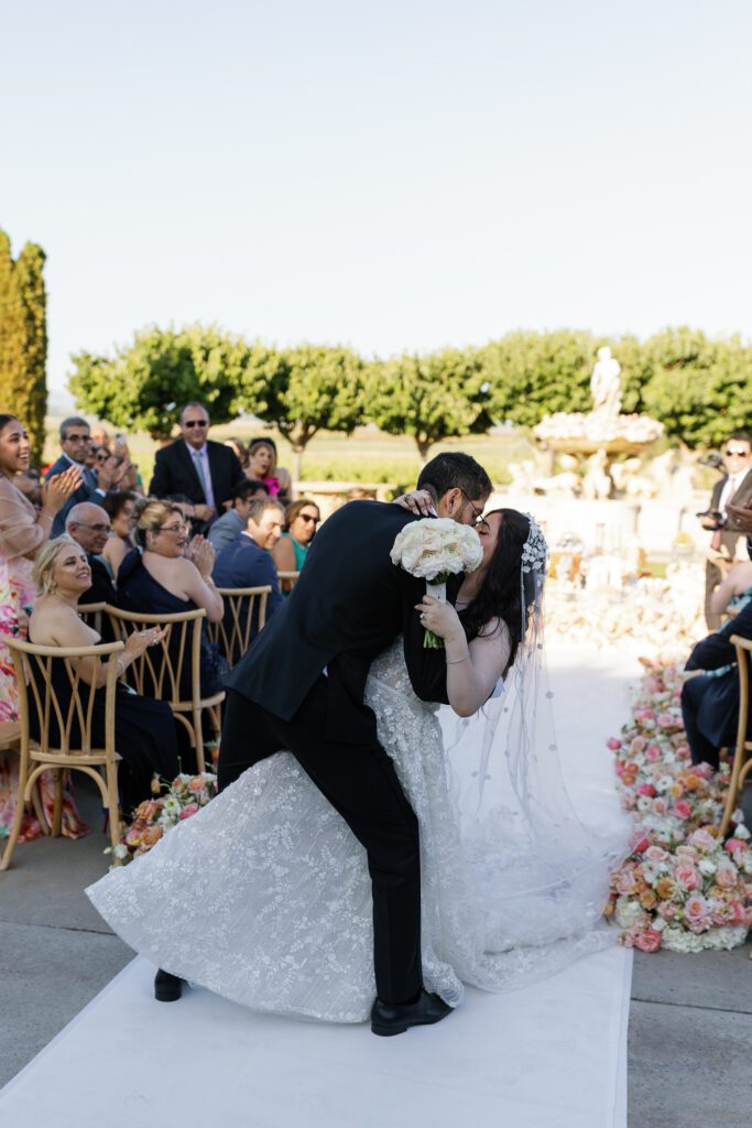 Bride and groom kissing at the end of their outdoor ceremony at Jacuzzi Winery
