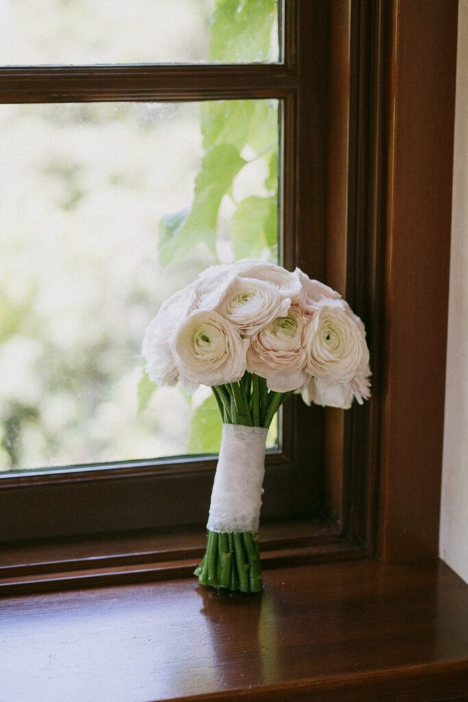 White rose bridal bouquet photographed by window at Jacuzzi Winery wedding
