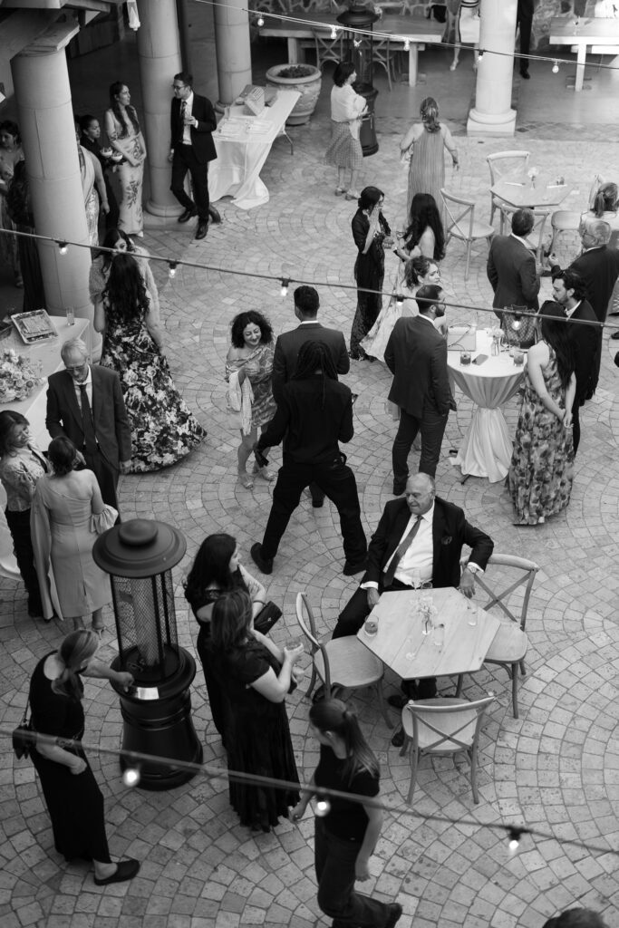 Black and white overhead view of wedding guests mingling during reception

