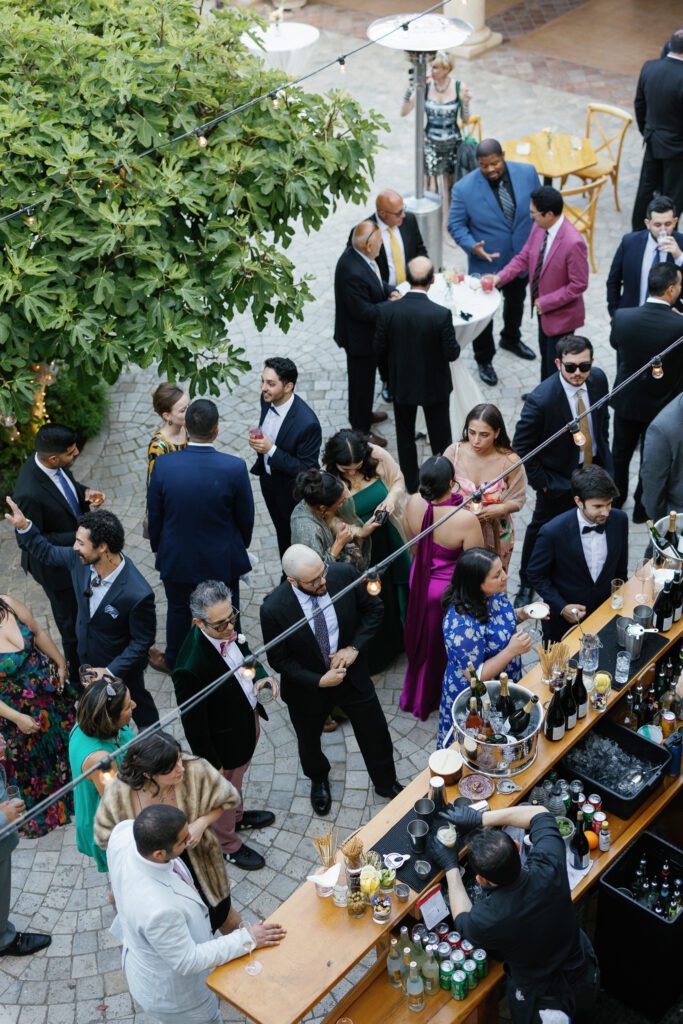 Wedding guests gathered around outdoor bar during reception at Jacuzzi Winery
