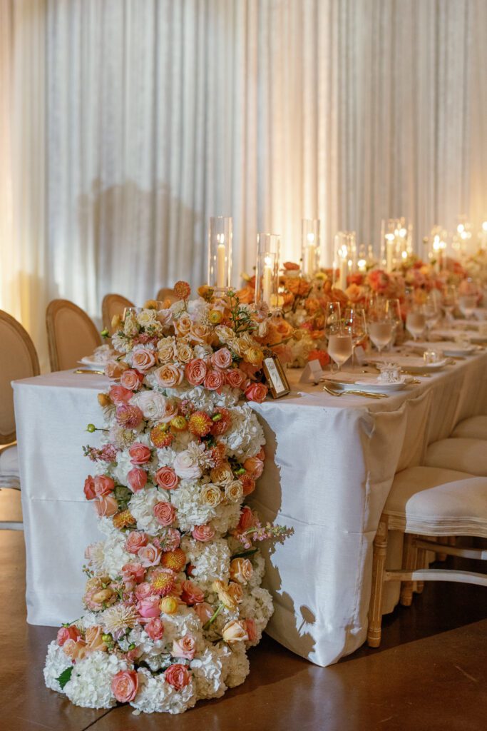 Wedding reception head table with lush floral installation designed by Florals by Hamid at Jacuzzi Winery
