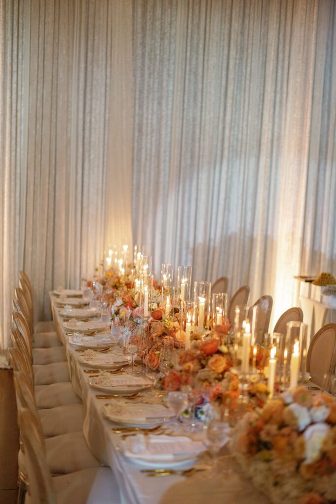Long wedding reception table with candlelight and florals designed by Florals by Hamid at Jacuzzi Winery
